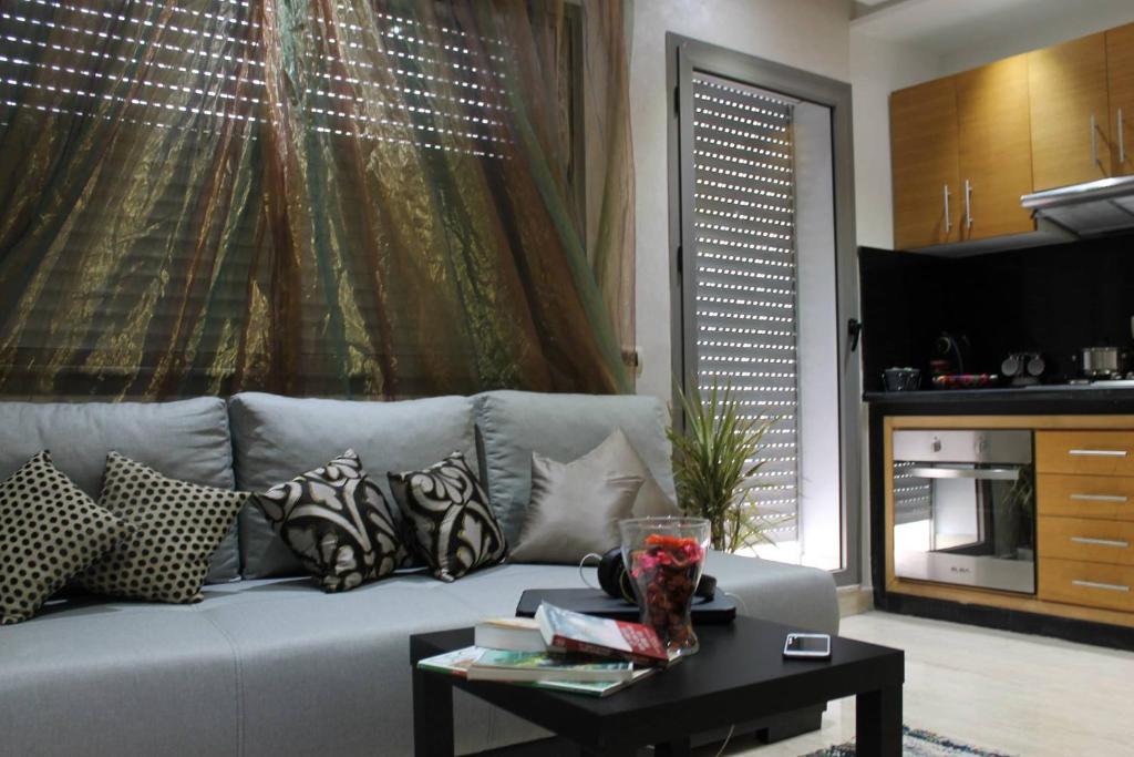 卡萨布兰卡Appartement Mogador的客厅配有沙发、枕头和桌子