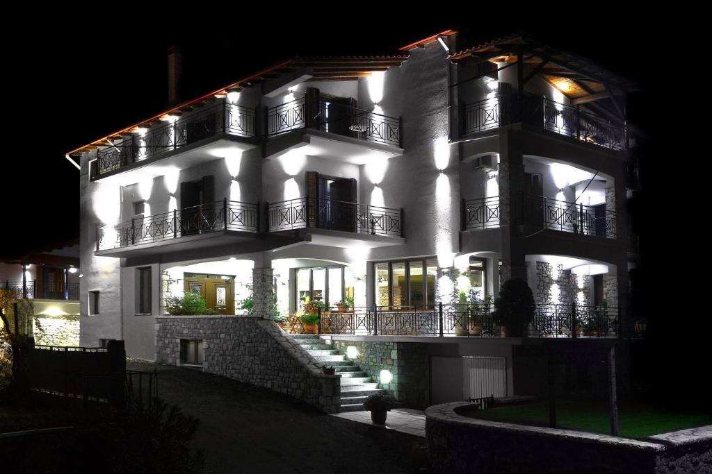 利韦迪昂Artemis Traditional Guesthouse的一座白色的大建筑,晚上有灯