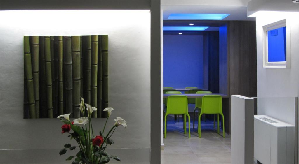 里乔内Hotel Sorriso - molto più di una stella的一间带桌子和绿色椅子的用餐室