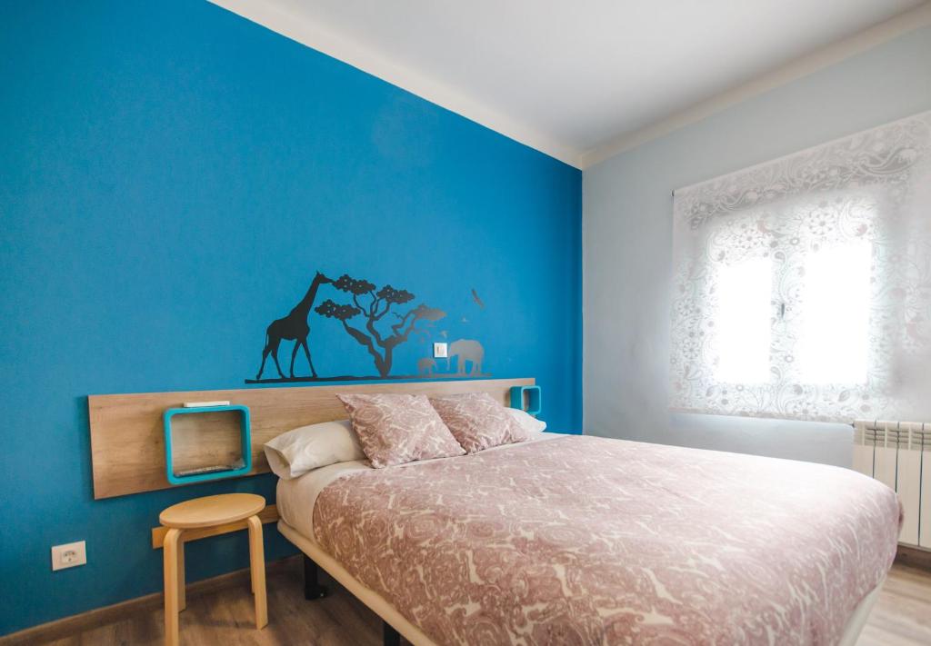 坎德莱达Hostal La Pastora的蓝色的卧室,配有床和蓝色的墙壁