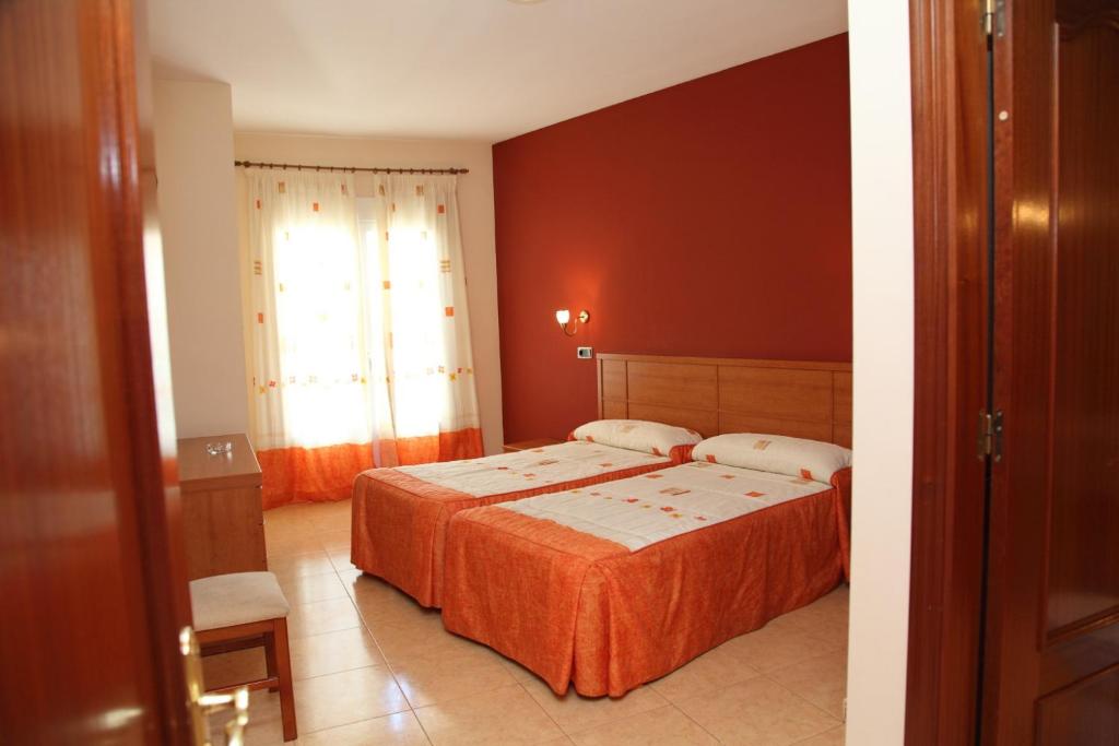 波索阿尔孔波索阿尔孔城市酒店的一间卧室设有两张床和红色的墙壁