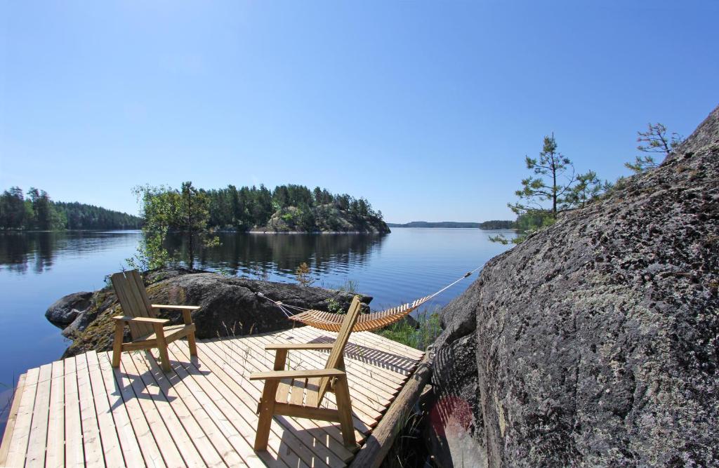 普马拉Okkolan Lomamökit的两把木椅坐在湖边的码头上