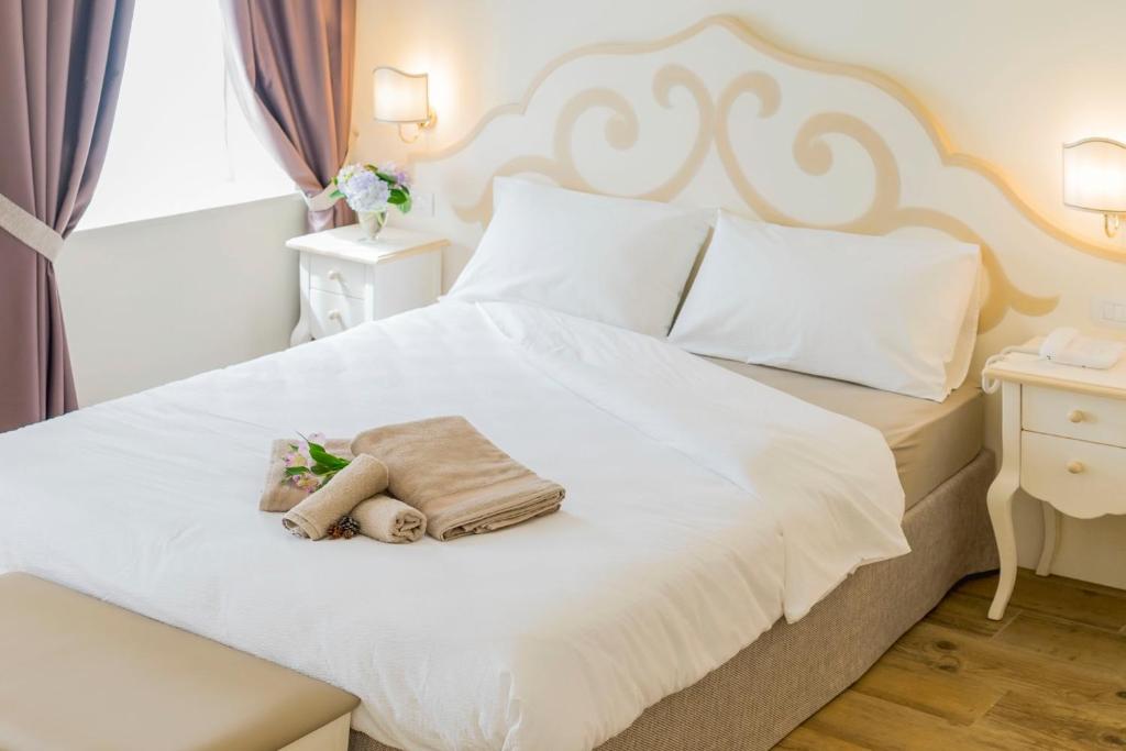 博斯科基耶萨诺瓦卡萨莱昂德奥罗酒店的卧室配有白色的床,上面有泰迪熊