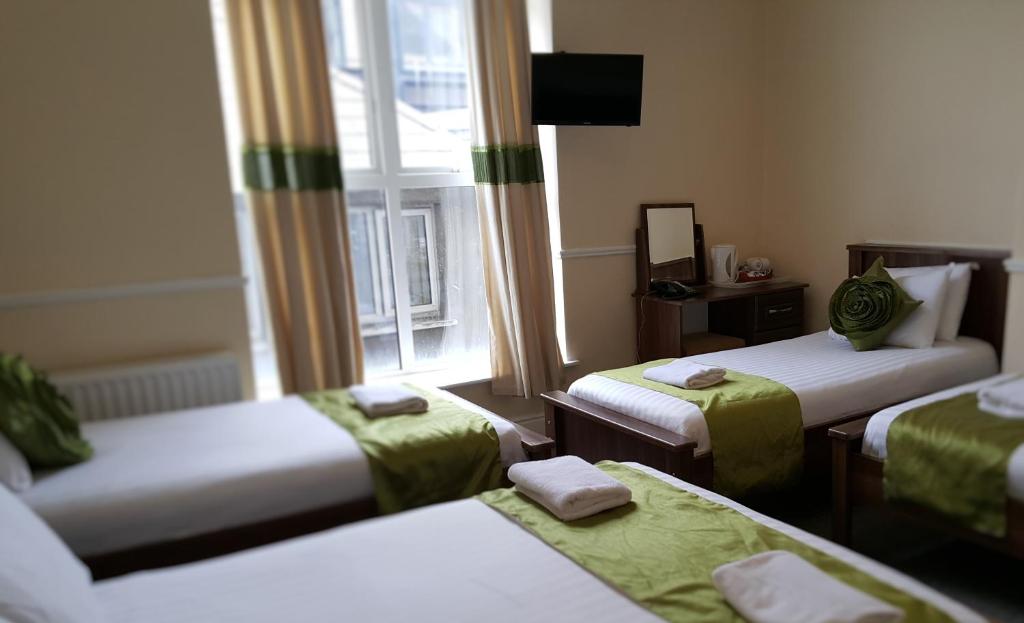 都柏林黑泽而布鲁克旅馆的带三张床和窗户的客房