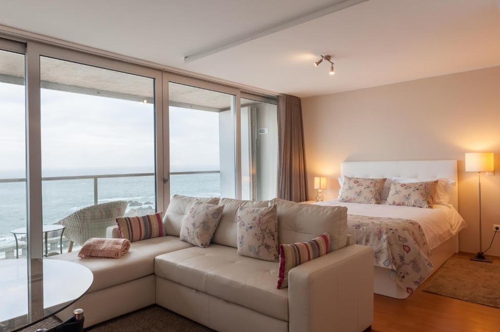 波尔图Bartolomeu Beach Apartments的客厅配有白色的沙发和床。