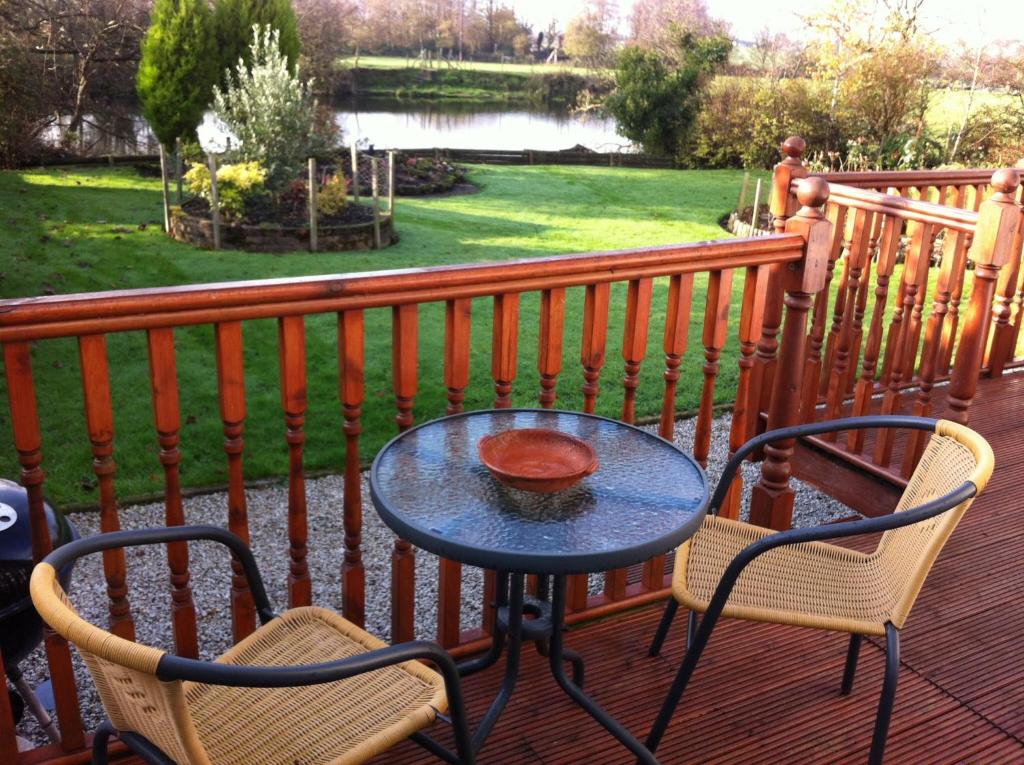 Great EcclestonMerok Lodge的公园景甲板上的桌椅
