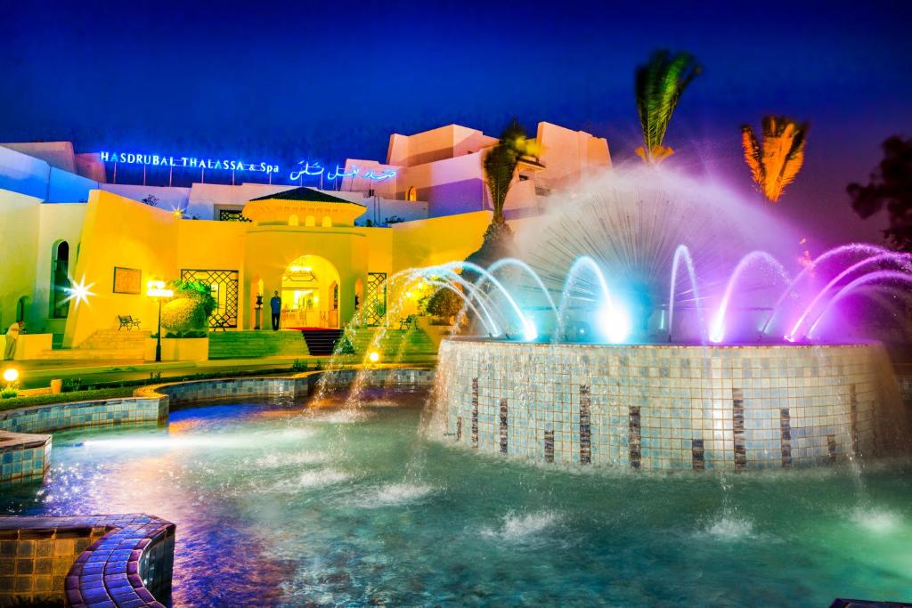 甘达坞伊港康大维港哈斯朱拔撒拉萨温泉酒店的夜间在建筑物前的喷泉
