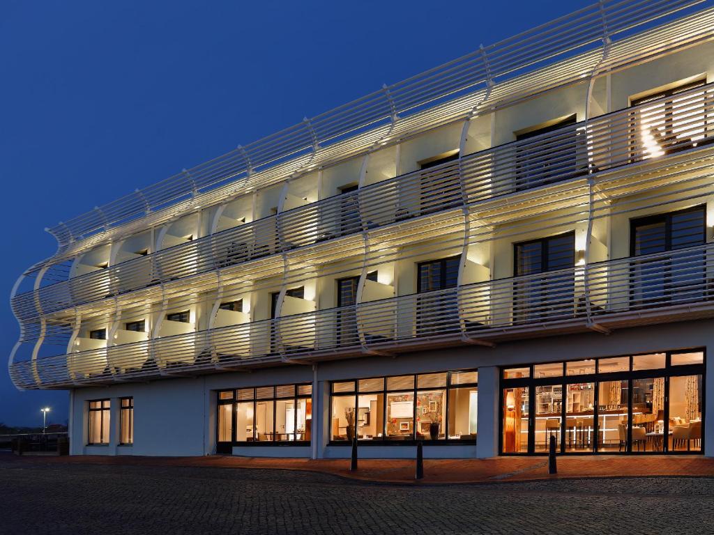 诺德代希Hotel Fährhaus的一座大型白色建筑,其侧面设有阳台