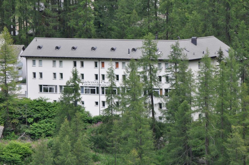 博斯克古林吉欧万尼博斯科假日旅舍的树木中间的白色大建筑