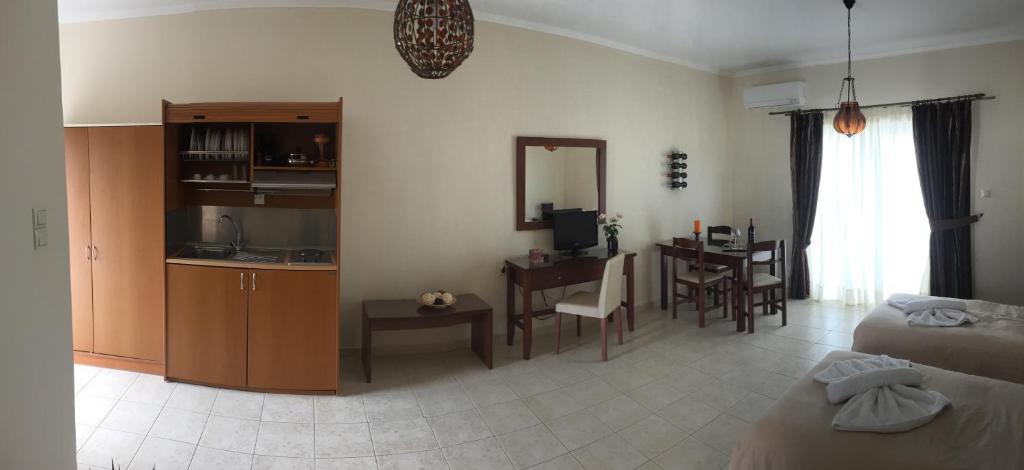 Kalloni卡罗尼皇家度假村的一间带一张床的客厅和一间带桌子的厨房