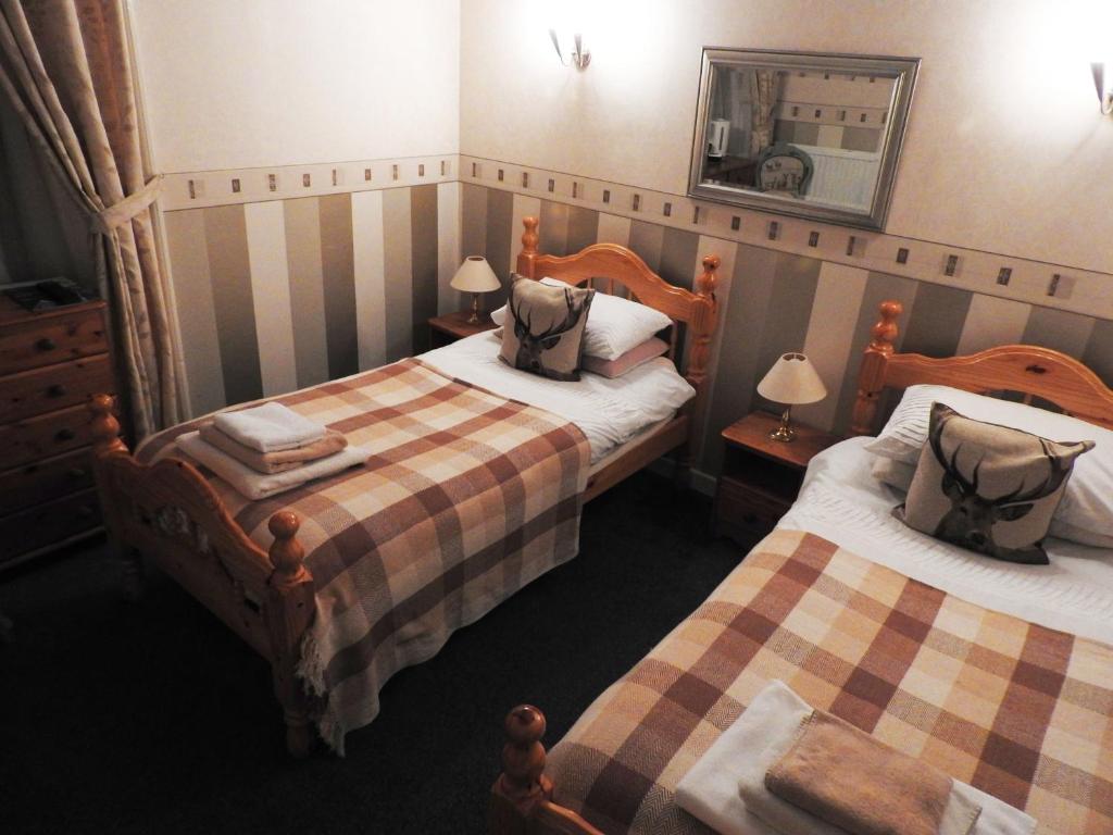 爱丁堡鹿头旅馆的酒店客房,设有两张床和镜子