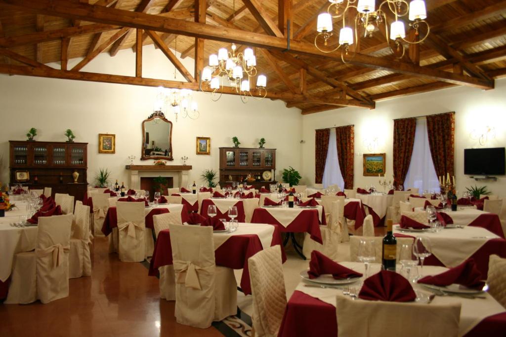 MussomeliAgriturismo Monticelli的一个带白色桌子和红色餐巾的大型宴会厅