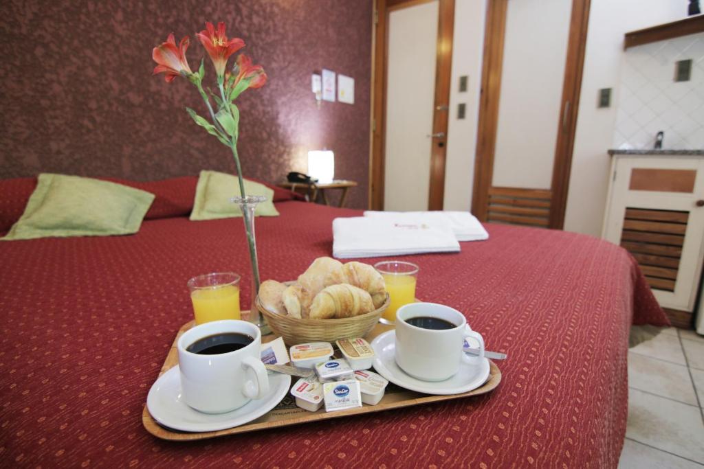 门多萨Hotel Xumec Mendoza的托盘,上面有两杯咖啡和一篮面包