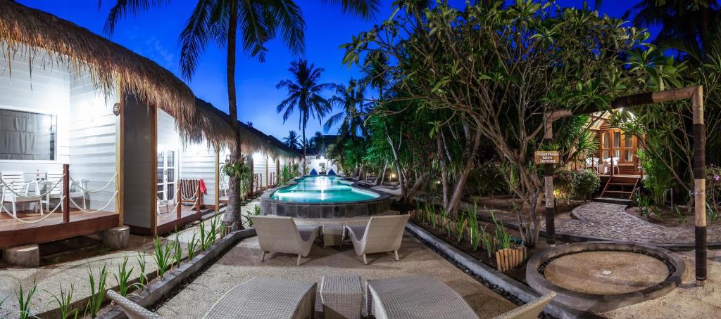 吉利特拉旺安吉利特拉万安 曼塔潜水度假酒店的庭院设有喷泉、椅子和树木