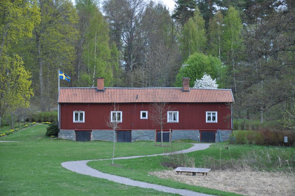 GrönsööThe Gardener House - Grönsöö Palace Garden的红谷仓顶部有旗帜