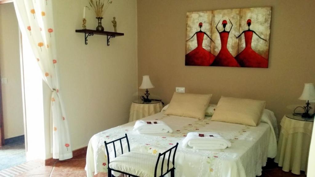 埃尔加斯托尔卡斯特尔普乐克斯酒店的一间卧室配有一张带两把椅子的床和一幅画