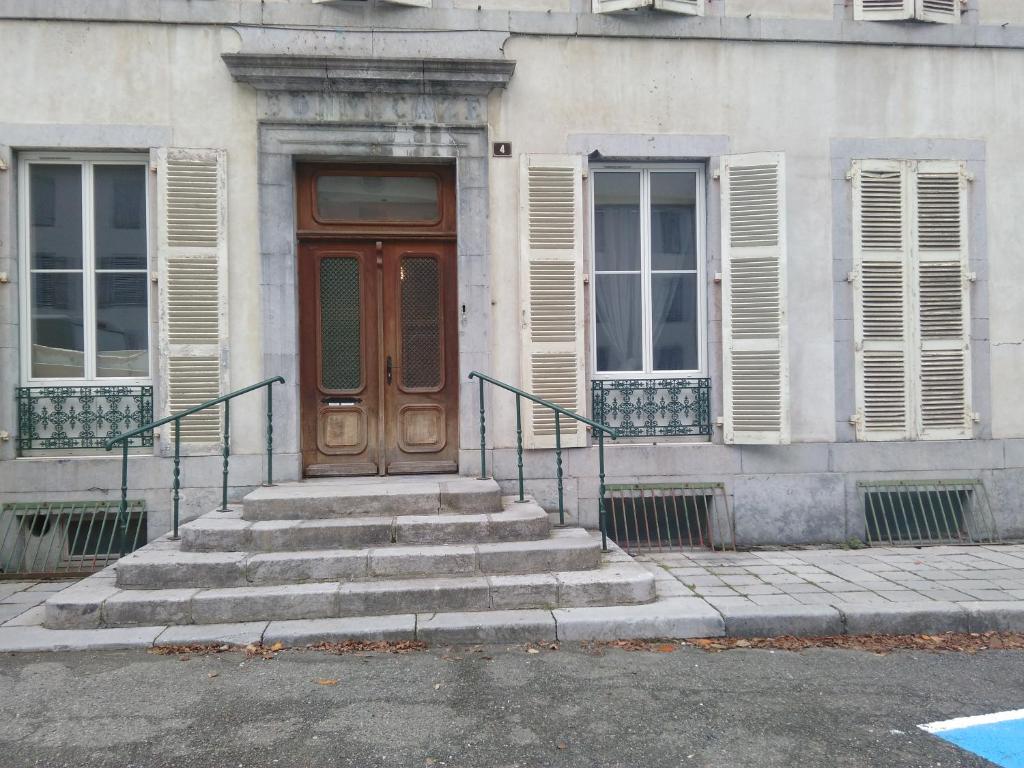 欧波讷Appartement Eaux bonnes的前方设有木门和楼梯的建筑