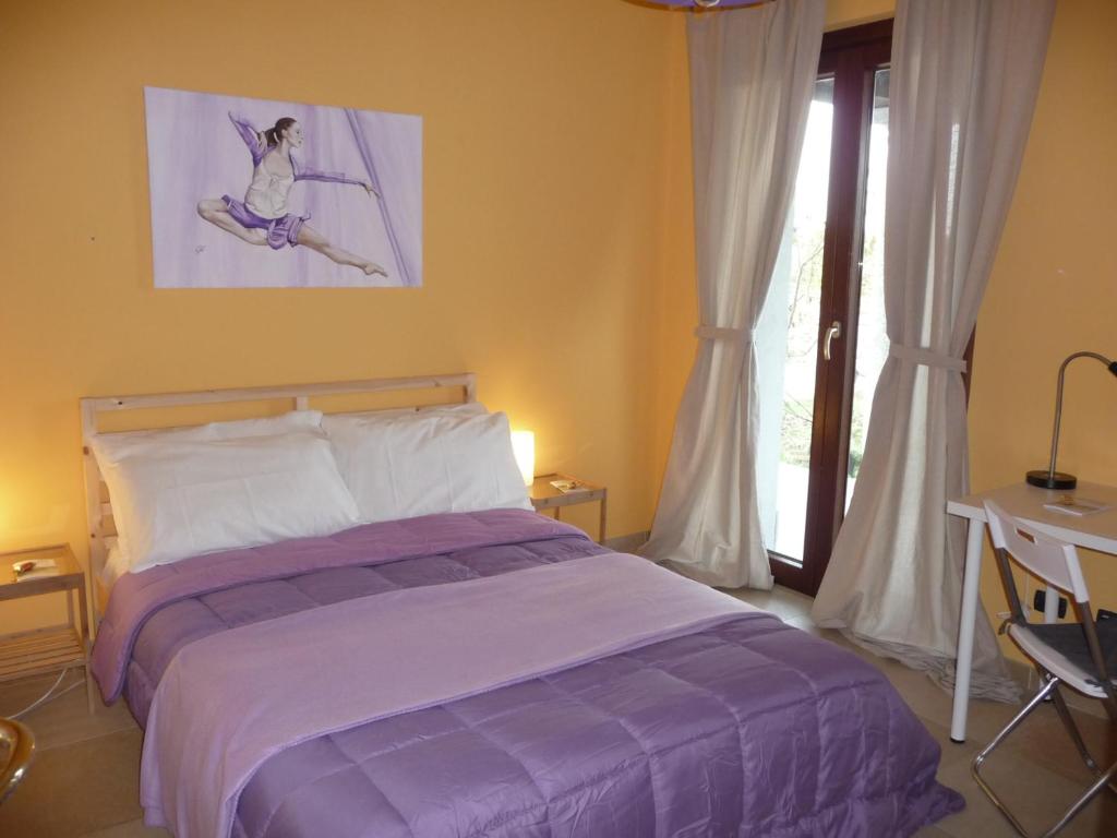 Casaleggio NovaraAmetista的一间卧室配有一张床、一张书桌和一个窗户。
