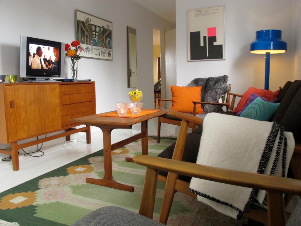 NorråkerBo på Lanthandel的客厅配有椅子、桌子和电视