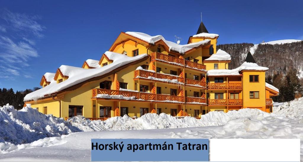 多纳瓦利Horský Apartmán Tatran的雪中酒店,有曲棍球公寓