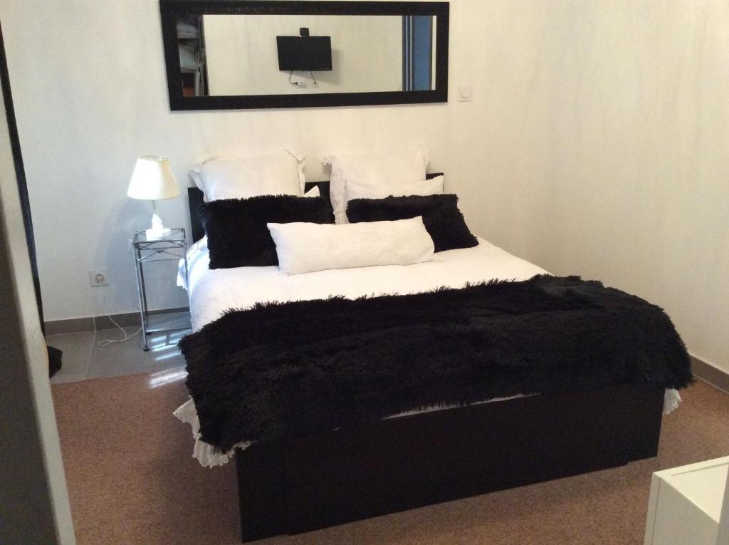 LavéruneLa Maison d'Estelle的一间卧室配有一张带黑白枕头的床