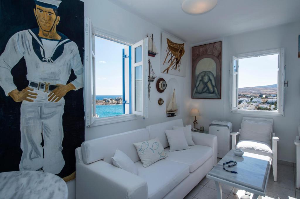 皮索利瓦迪Aiolos Home with private veranda and amazing sea views, Paros的客厅配有白色沙发,画有水手画