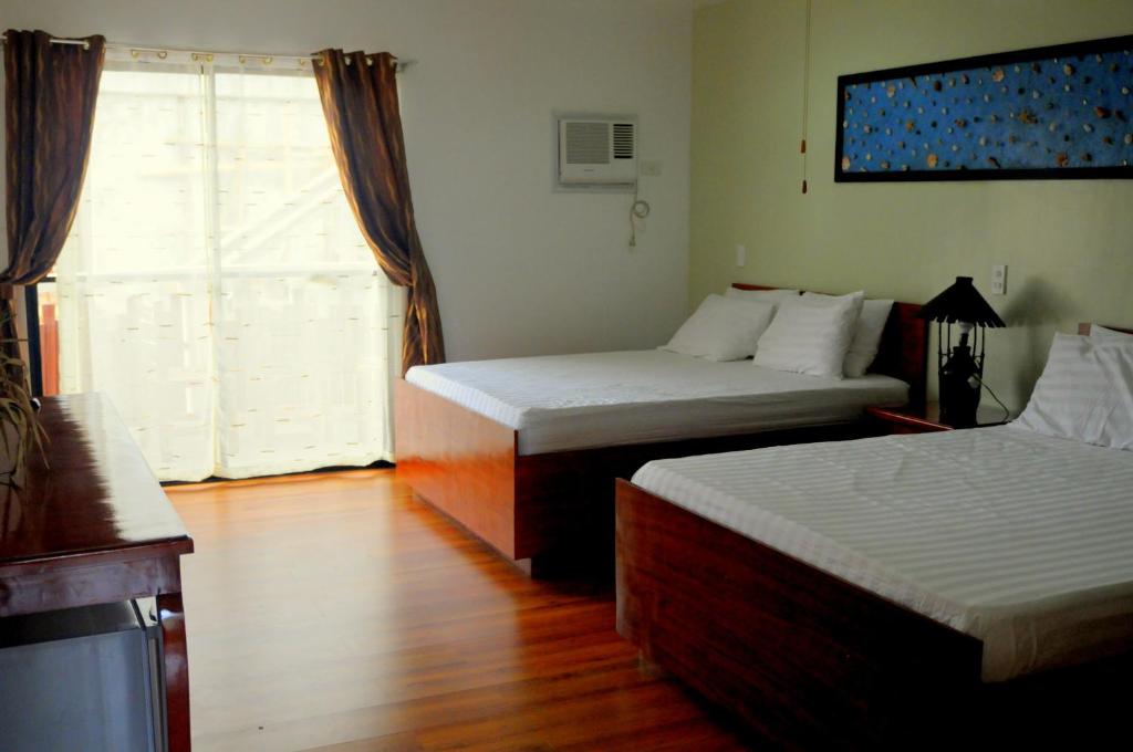 长滩岛绿洲度假酒店的酒店客房设有两张床和窗户。