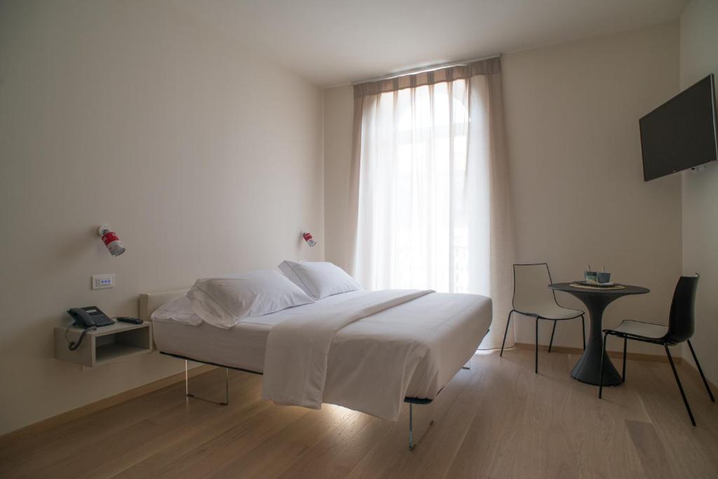 维罗纳Verona Design的白色的卧室设有床和窗户