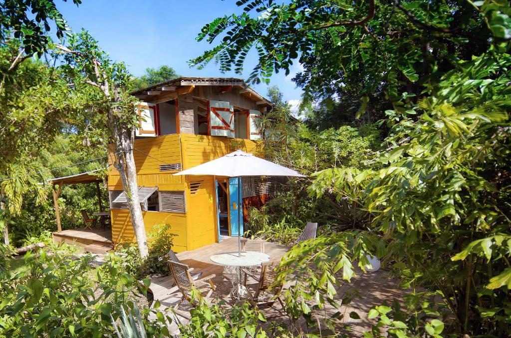 圣弗朗索瓦智慧加勒比度假屋的黄色的房子,配有桌子和雨伞