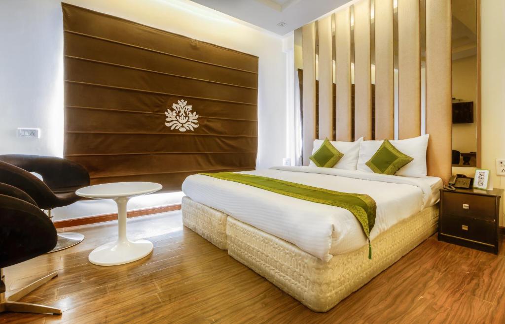 新德里Hotel Gold Souk - Karol Bagh的一间卧室配有一张床、一把椅子和一张桌子