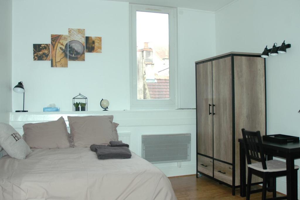 第戎Le Cosy Musette - Rue Piétonne的一间卧室配有一张床、一张书桌和一个窗户。
