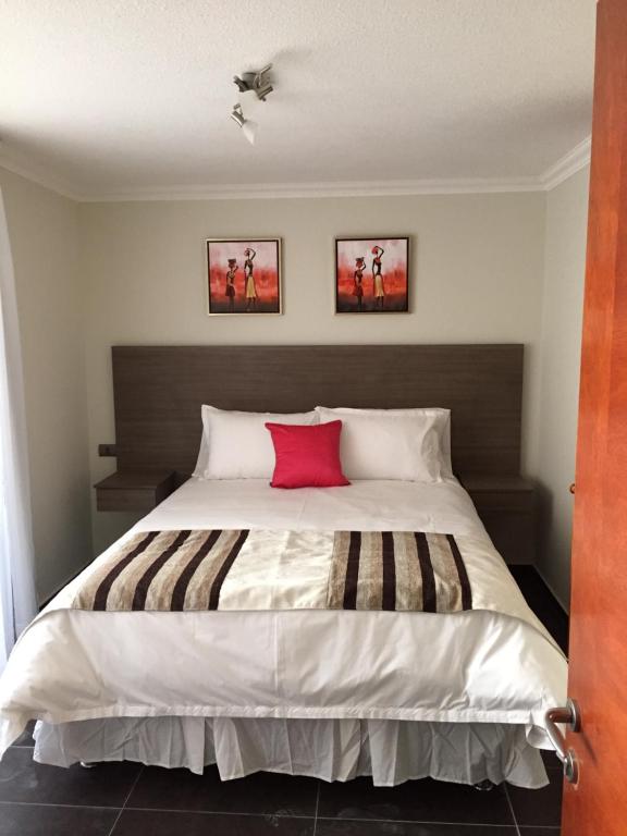 安托法加斯塔Tempora Apart Hotel的一间卧室配有一张带红色枕头的大床