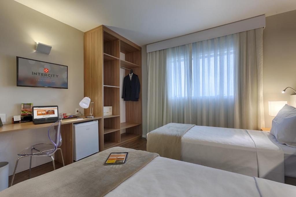 贝洛奥里藏特Intercity BH Expo的酒店客房设有两张床和窗户。