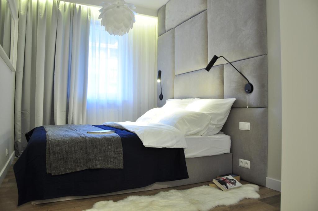 罗兹City Rent Apartments的一间卧室设有一张大床和大窗户
