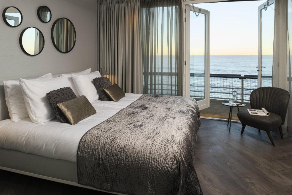 斯海弗宁恩De Pier Suites的一间卧室设有一张床,享有海景