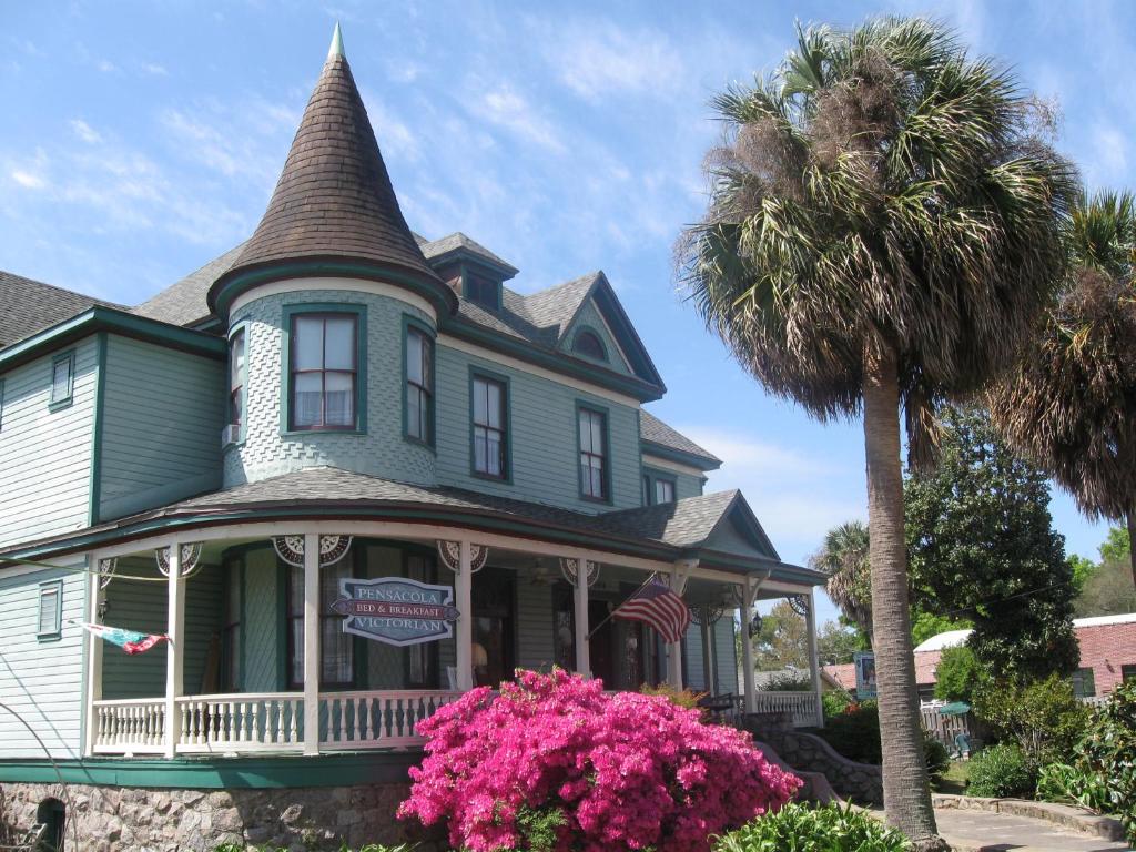 彭萨科拉Pensacola Victorian Bed & Breakfast的前面有棕榈树的房子