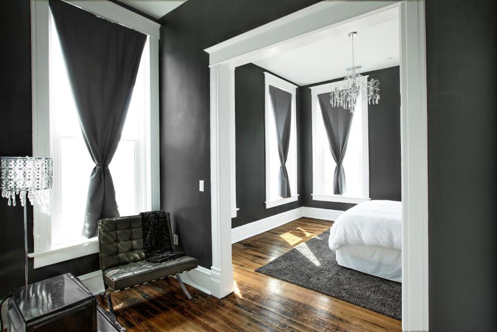 McCammonThe Harkness Hotel的卧室设有黑色墙壁、一张床和椅子