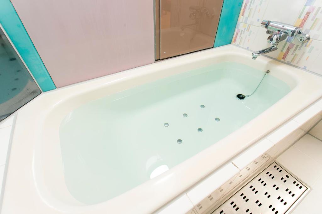东京莫阿纳大冢酒店（仅限成人）的浴室内设有带水龙头的白色浴缸