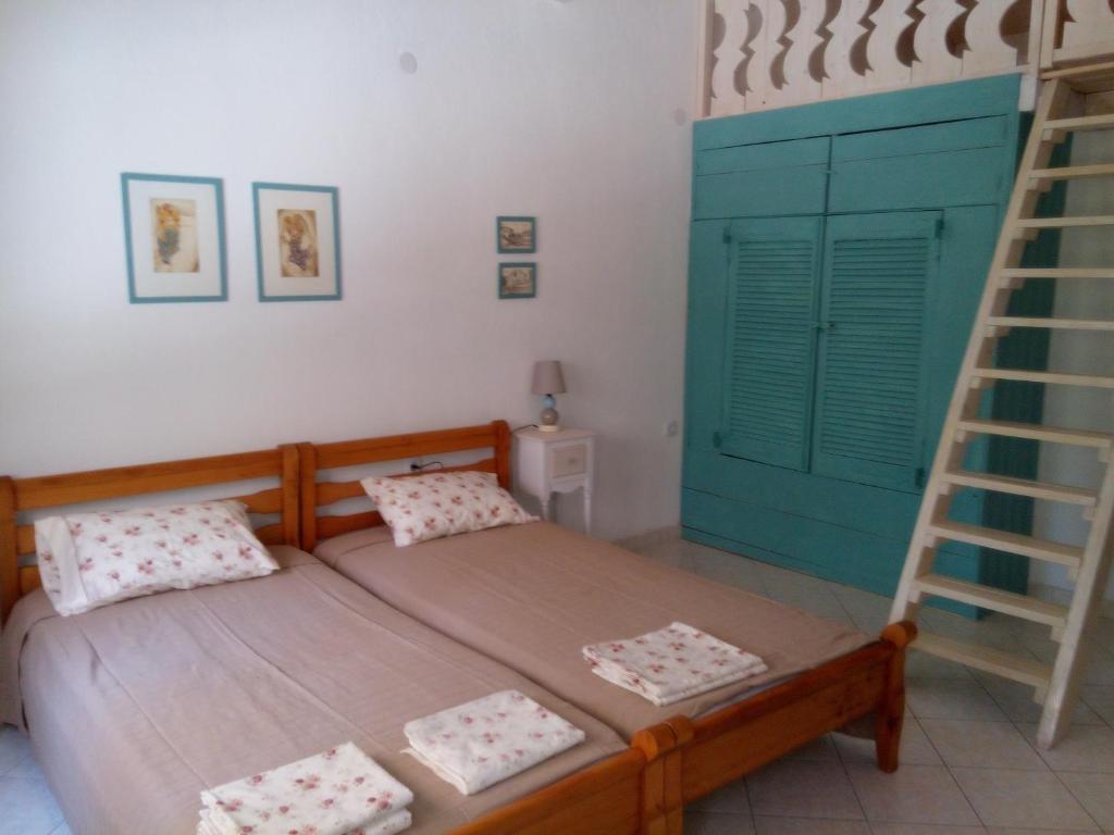 Mikrós PrínosSmaragda Studios的一间卧室配有一张带梯子的床和一张双层床。