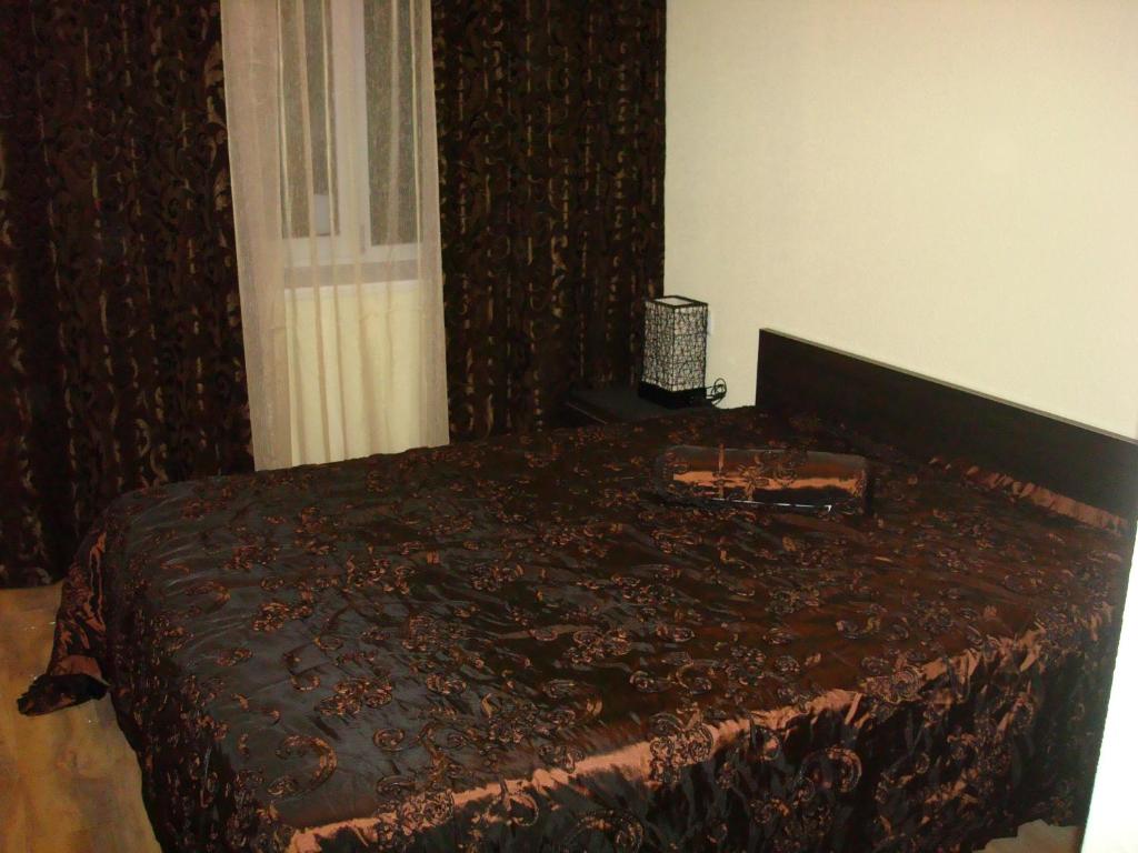 第聂伯罗Отель Гармония的一间卧室配有一张带棕色毯子的床
