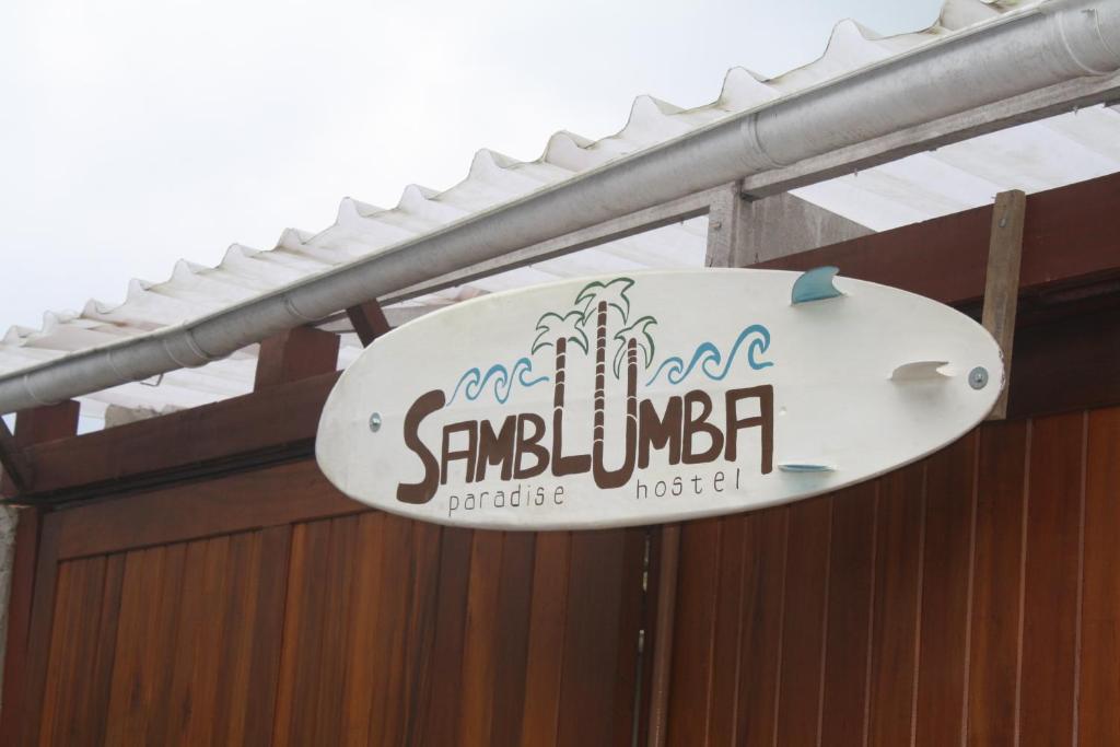 特林达德Samblumba Hostel Trindade的建筑上的标志,上面有冲浪板