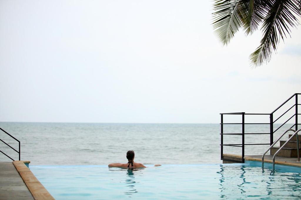 柴瑞海滩36 Palms Boutique Retreat的游泳池里的人,远眺大海