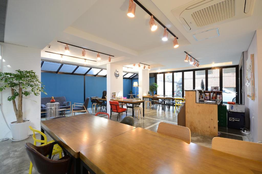 首尔Sunnyhill Hostel Hongdae的一个带大木桌和椅子的办公室
