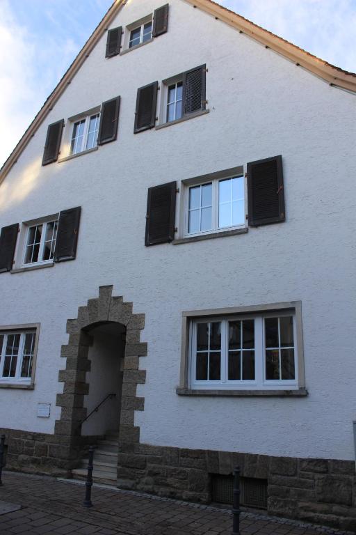 厄林根Bismarck Hostel Öhringen的白色的建筑,上面有黑色百叶窗