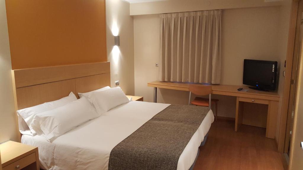 安道尔城埃斯佩尔酒店的酒店客房配有一张床、一张书桌和一台电视。