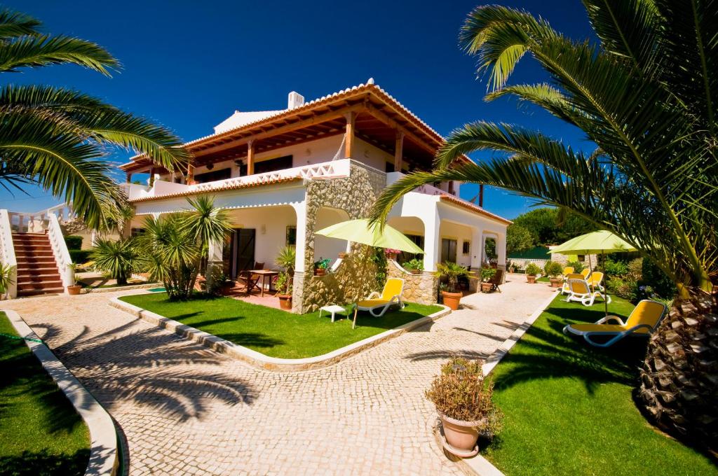 萨格里什君悦胡里奥酒店的一座带花园和棕榈树的别墅