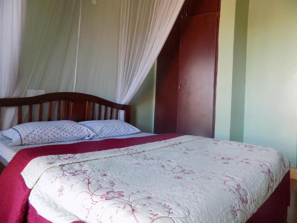 姆巴拉拉Hotel Shine Sunet的一间卧室配有一张带红白毯子的床