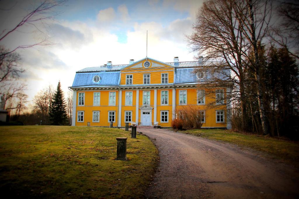 SvartåMustion Linna / Svartå Manor的蓝色屋顶的大型黄色建筑