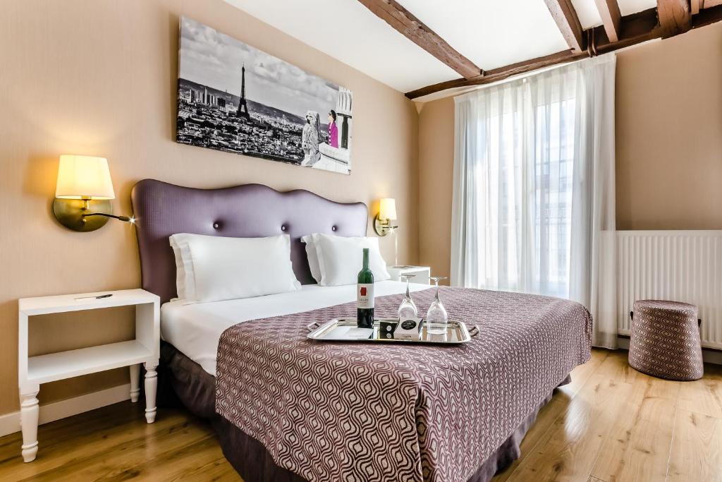 巴黎Exe Paris Centre的酒店客房带一张带紫色床罩的床