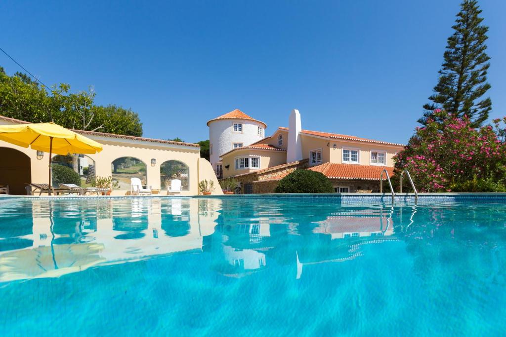 辛特拉Quinta do Cabo Guesthouse的房屋前的游泳池